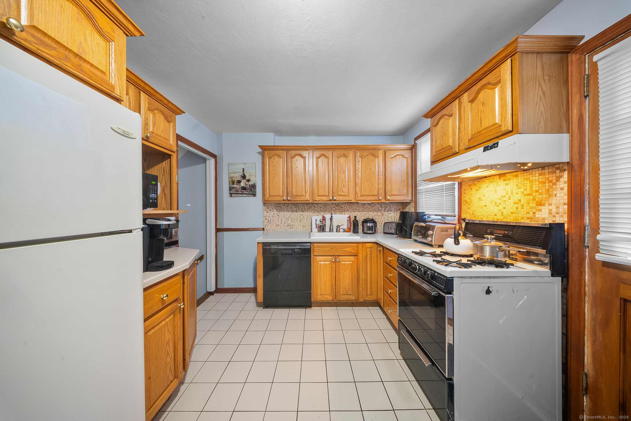 274 Sylvan Knoll Road Stamford, CT 06902 - Photo 9 of 21 a kitchen with a sink a counter top space stainless steel appliances and a window