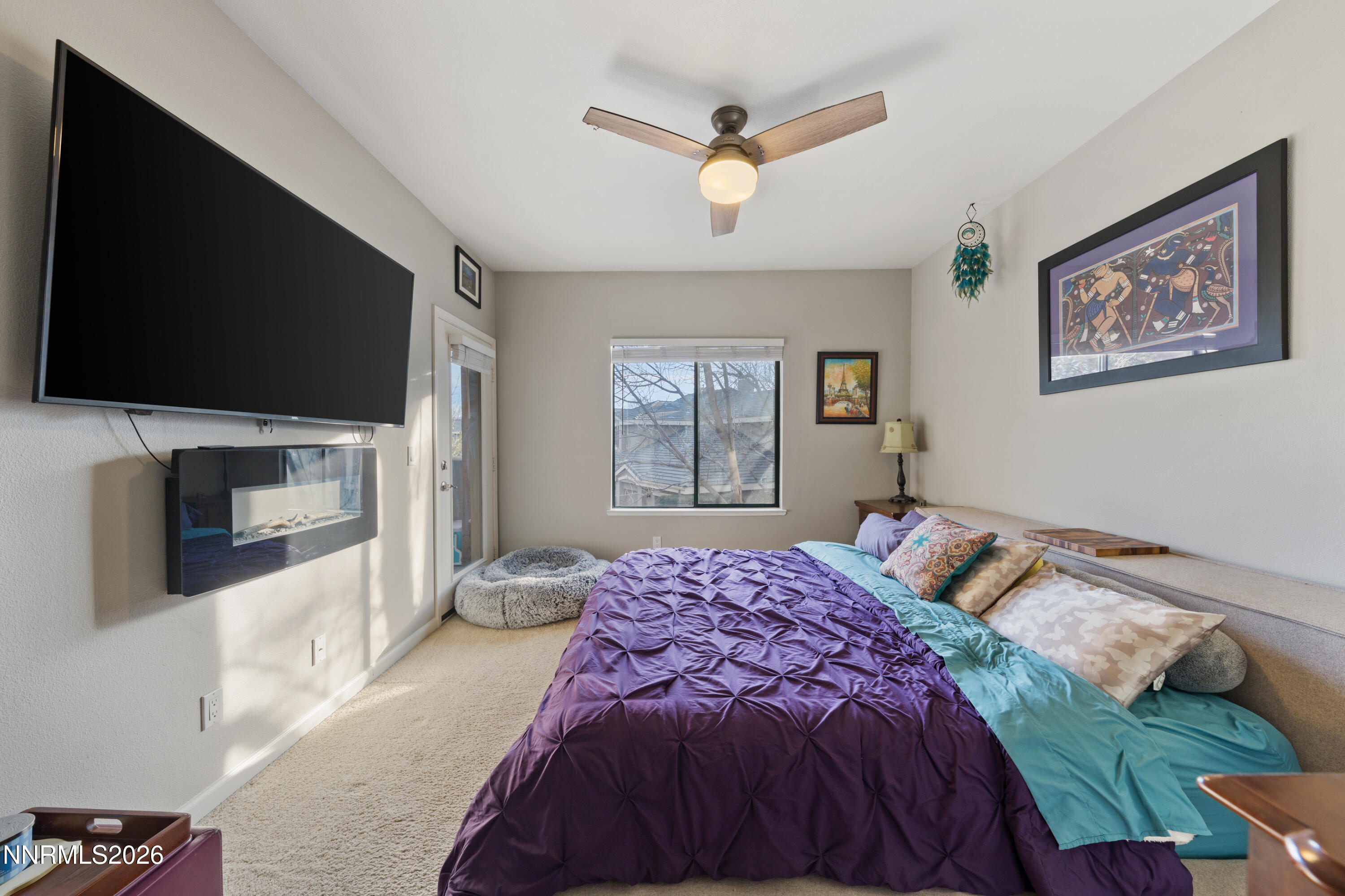 900 South Meadows Parkway, Unit 3222 Reno, NV 89521 - Photo 29 of 43 a bedroom with a large bed a flat tv screen and a fireplace