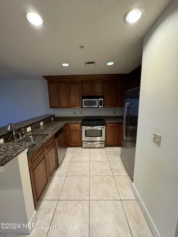 a kitchen with stainless steel appliances granite countertop a sink and cabinets