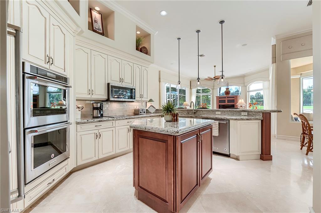 10200 Orchid Ridge Lane Estero, FL 34135 - Photo 12 of 50 a kitchen with stainless steel appliances granite countertop a stove top oven a sink dishwasher and a refrigerator with wooden floor