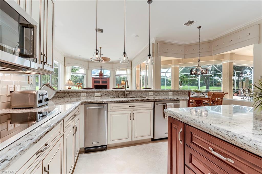 10200 Orchid Ridge Lane Estero, FL 34135 - Photo 13 of 50 a kitchen with stainless steel appliances granite countertop a sink a stove and a wooden floor