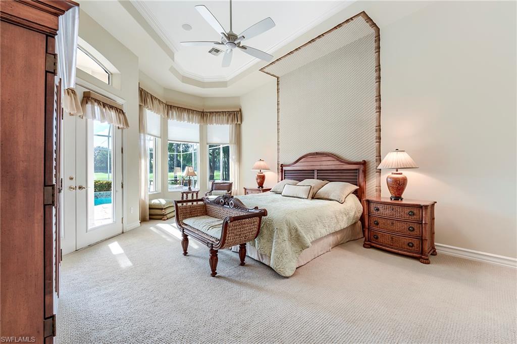 10200 Orchid Ridge Lane Estero, FL 34135 - Photo 19 of 50 a bedroom with a bed and a chandelier