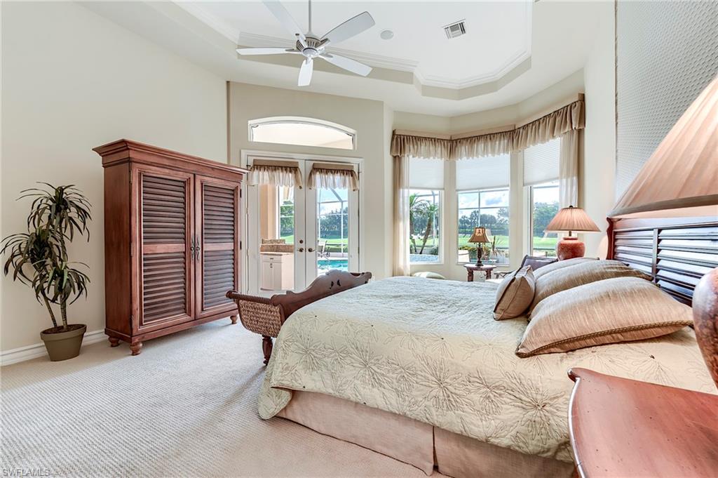 10200 Orchid Ridge Lane Estero, FL 34135 - Photo 20 of 50 a bedroom with a bed and a chandelier