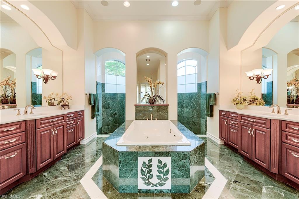 10200 Orchid Ridge Lane Estero, FL 34135 - Photo 21 of 50 a large spacious bathroom with a granite countertop tub a double vanity sink and a mirror