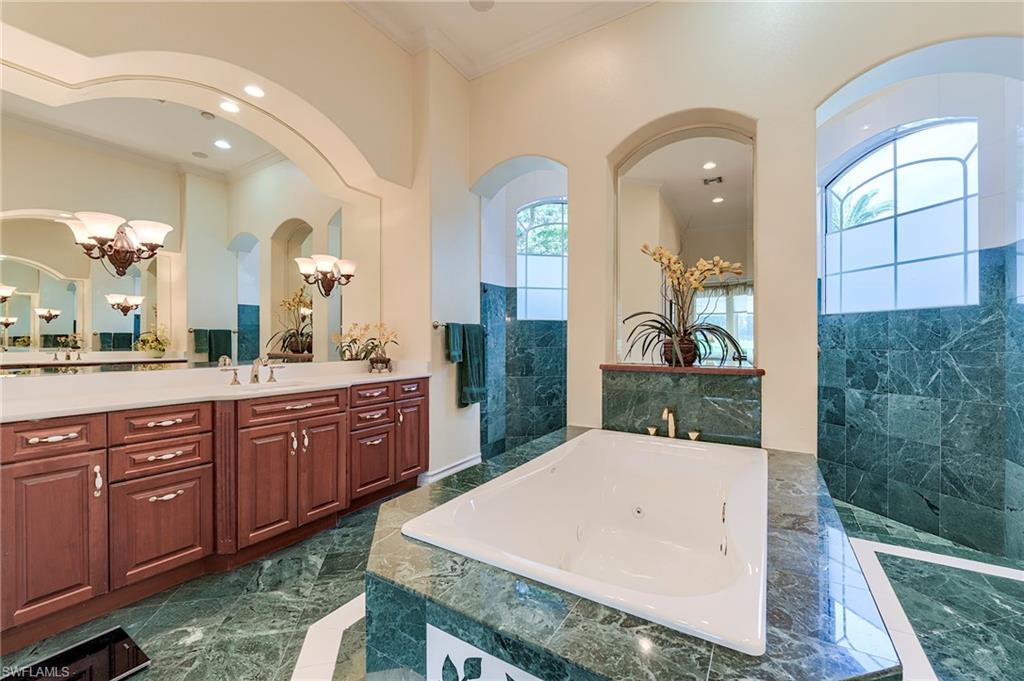 10200 Orchid Ridge Lane Estero, FL 34135 - Photo 22 of 50 a spacious bathroom with a granite countertop sink a mirror and shower