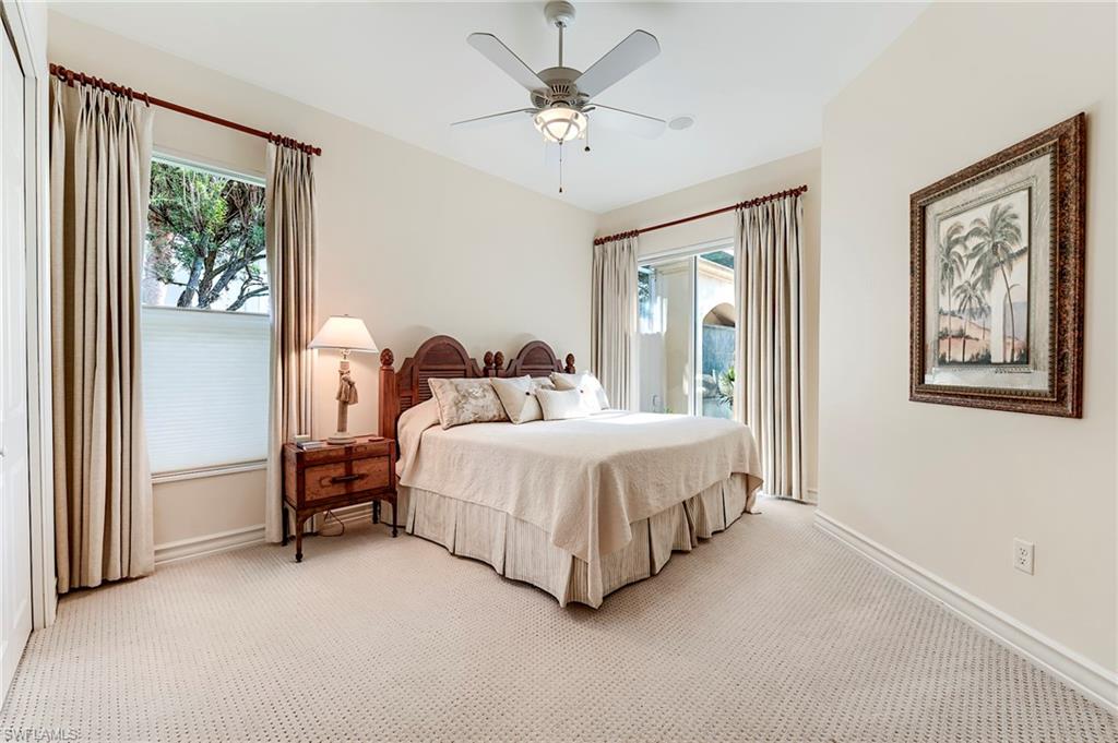 10200 Orchid Ridge Lane Estero, FL 34135 - Photo 23 of 50 a spacious bedroom with a bed painting on wall and a large window