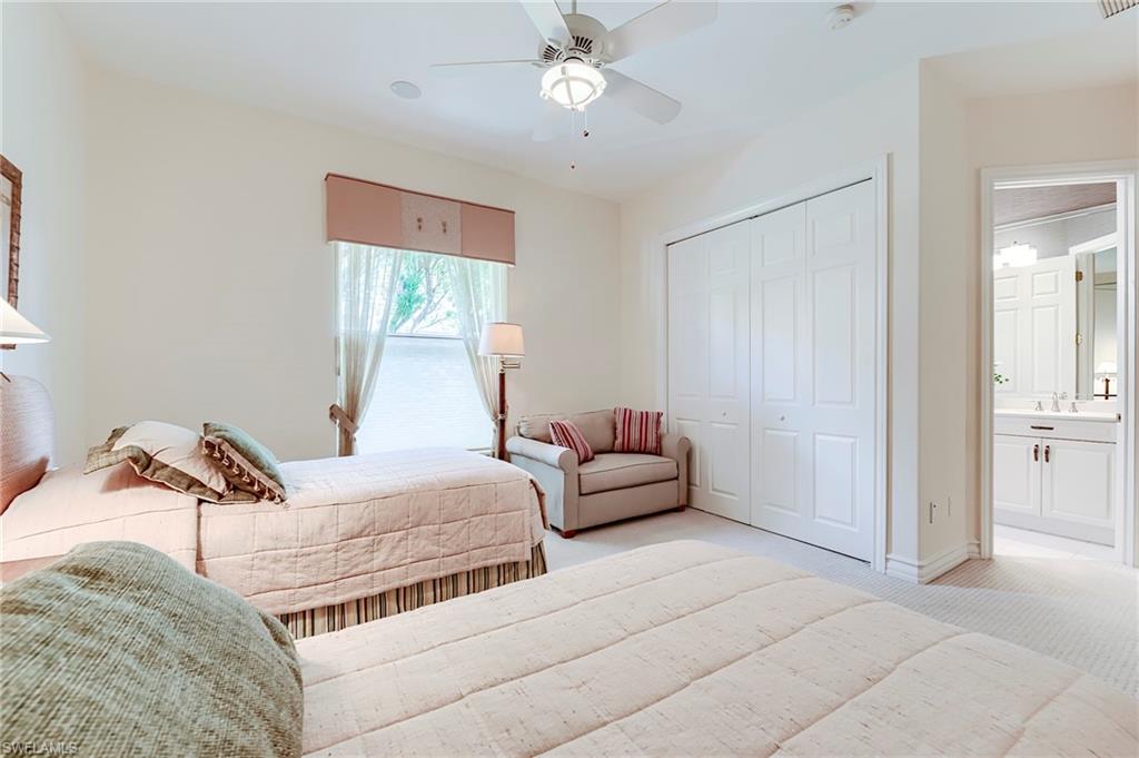10200 Orchid Ridge Lane Estero, FL 34135 - Photo 26 of 50 a bedroom with a bed and a chandelier