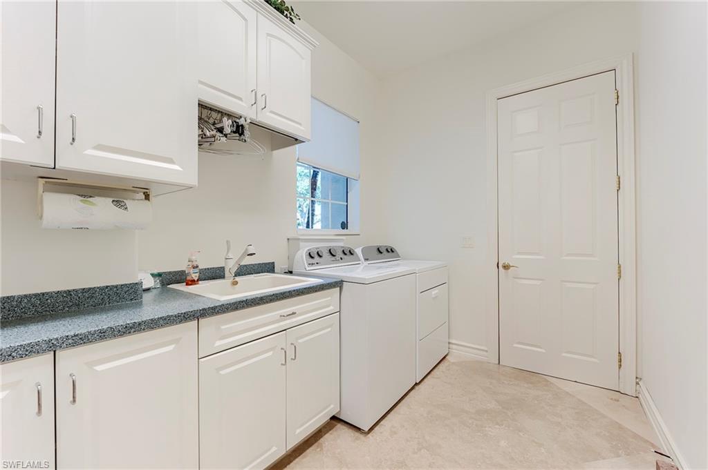 10200 Orchid Ridge Lane Estero, FL 34135 - Photo 28 of 50 a utility room with cabinets washer and dryer