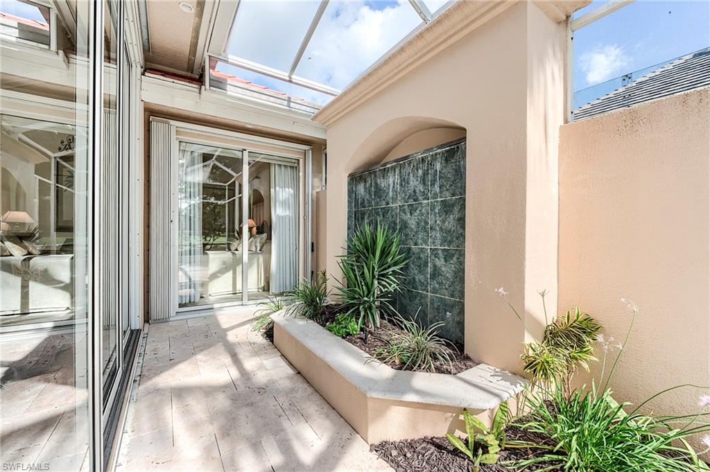 10200 Orchid Ridge Lane Estero, FL 34135 - Photo 33 of 50 a house with potted plants in front of door