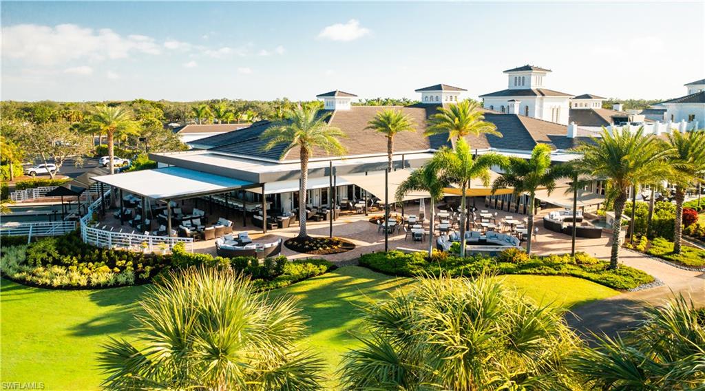 10200 Orchid Ridge Lane Estero, FL 34135 - Photo 37 of 50 a view of a swimming pool with a table and chairs under an umbrella