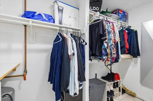 a view of walk in closet with clothes and shoes