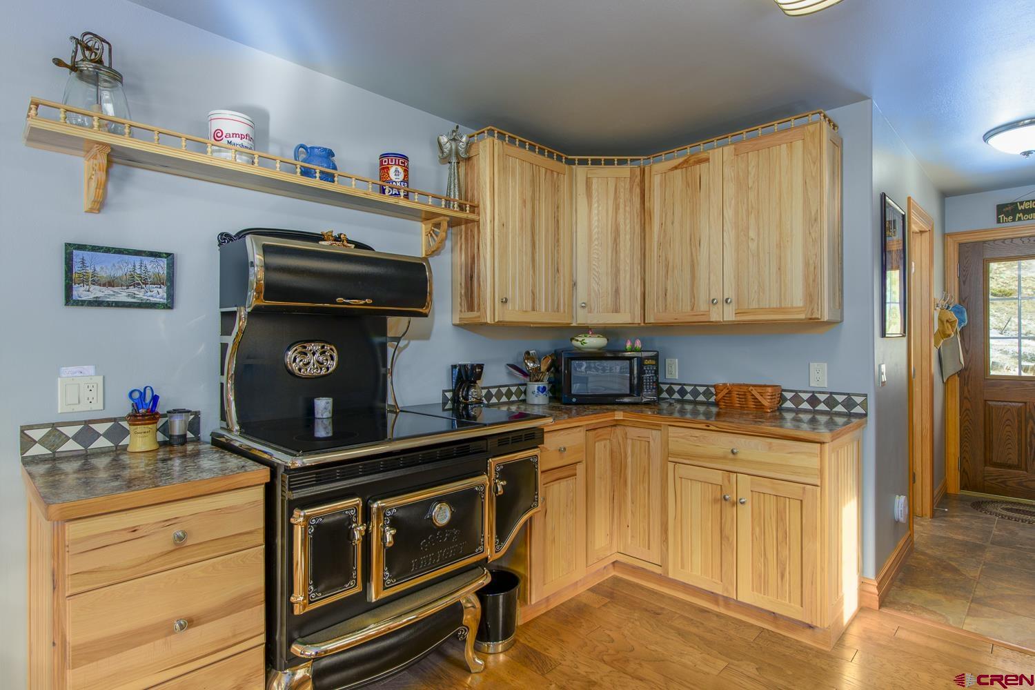 825-823 Main Street Pitkin, CO 81241 - Photo 12 of 42 a kitchen with stainless steel appliances a stove a microwave and cabinets