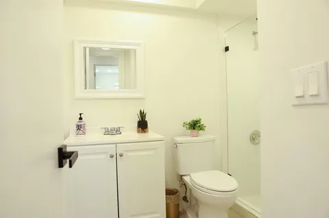 a bathroom with a toilet sink vanity and mirror