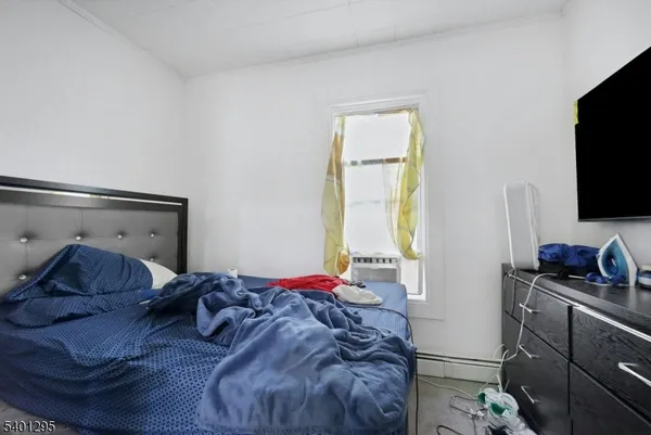 a bedroom with a bed and a flat tv screen on a dresser