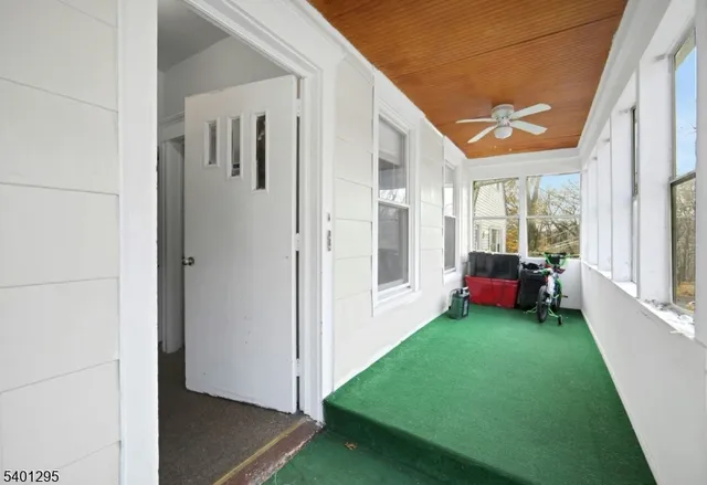 a view of a porch with furniture and floor to ceiling window