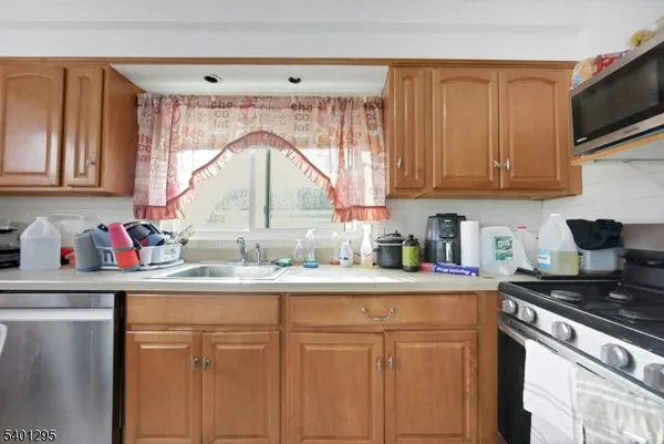 a kitchen with kitchen island granite countertop a sink cabinets and window