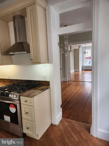 a kitchen with granite countertop a stove and a wooden floor