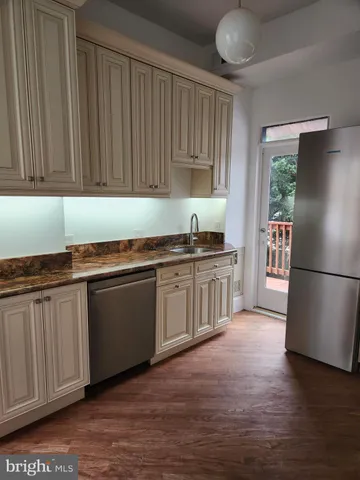 a kitchen with granite countertop stainless steel appliances a sink cabinets and a counter top space