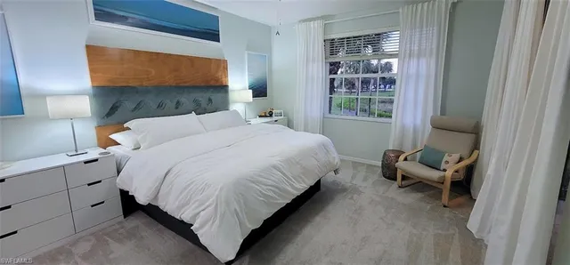 a bedroom with a bed chair and lamp