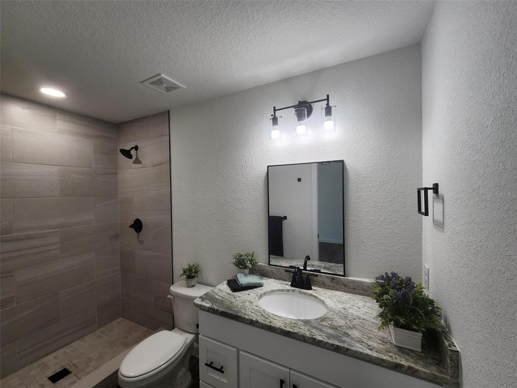 820 Redwood Road Dunnellon, FL 34431 - Photo 12 of 28 a bathroom with a granite countertop sink toilet a large mirror a shower and a mirror