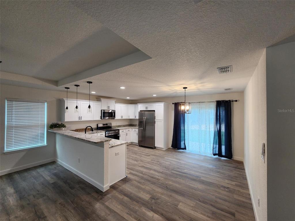 820 Redwood Road Dunnellon, FL 34431 - Photo 9 of 28 a kitchen with stainless steel appliances kitchen island wooden cabinets and granite counter tops
