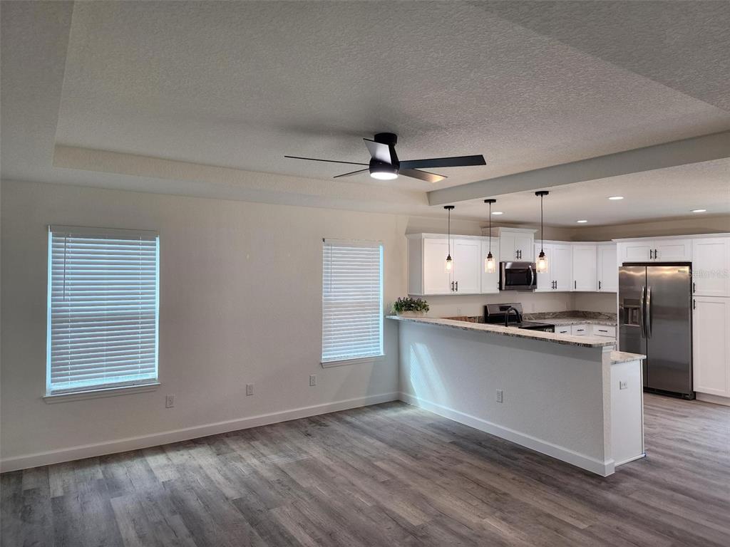 820 Redwood Road Dunnellon, FL 34431 - Photo 10 of 28 a kitchen with stainless steel appliances a sink a stove a refrigerator cabinets and a wooden floor