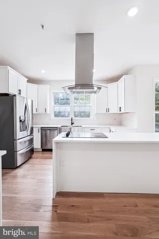 a large kitchen with granite countertop a large counter top stainless steel appliances and cabinets