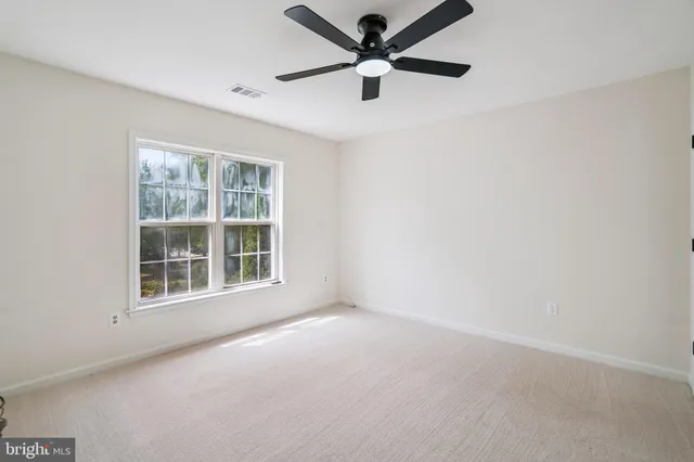 an empty room with a window and a fan