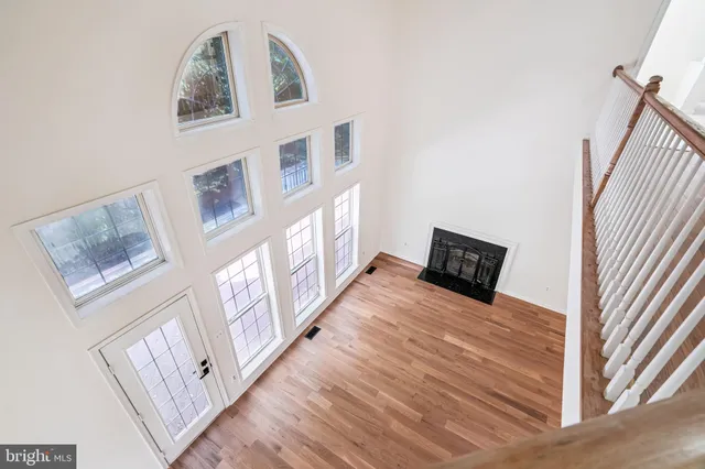 a view of a bedroom with wooden floor and windows