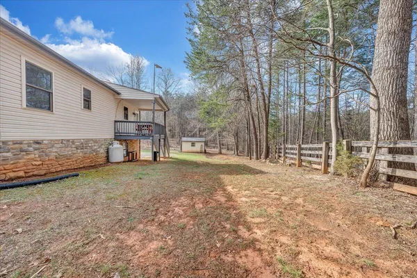 a view of a house with backyard and tree