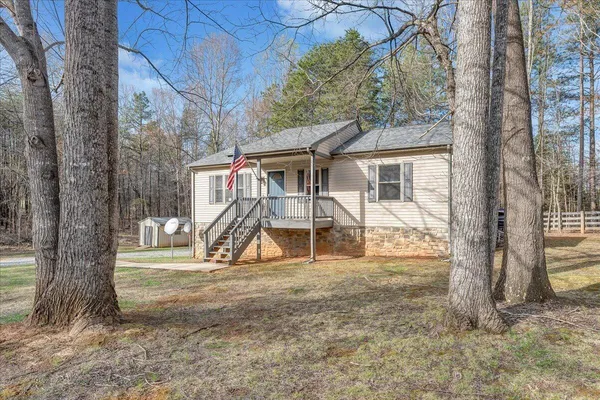 a view of a house with a yard and trees