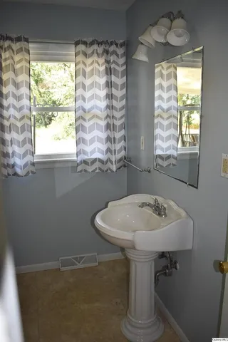a bathroom with a sink a mirror and a window