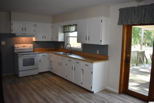 a kitchen with granite countertop white cabinets and white appliances