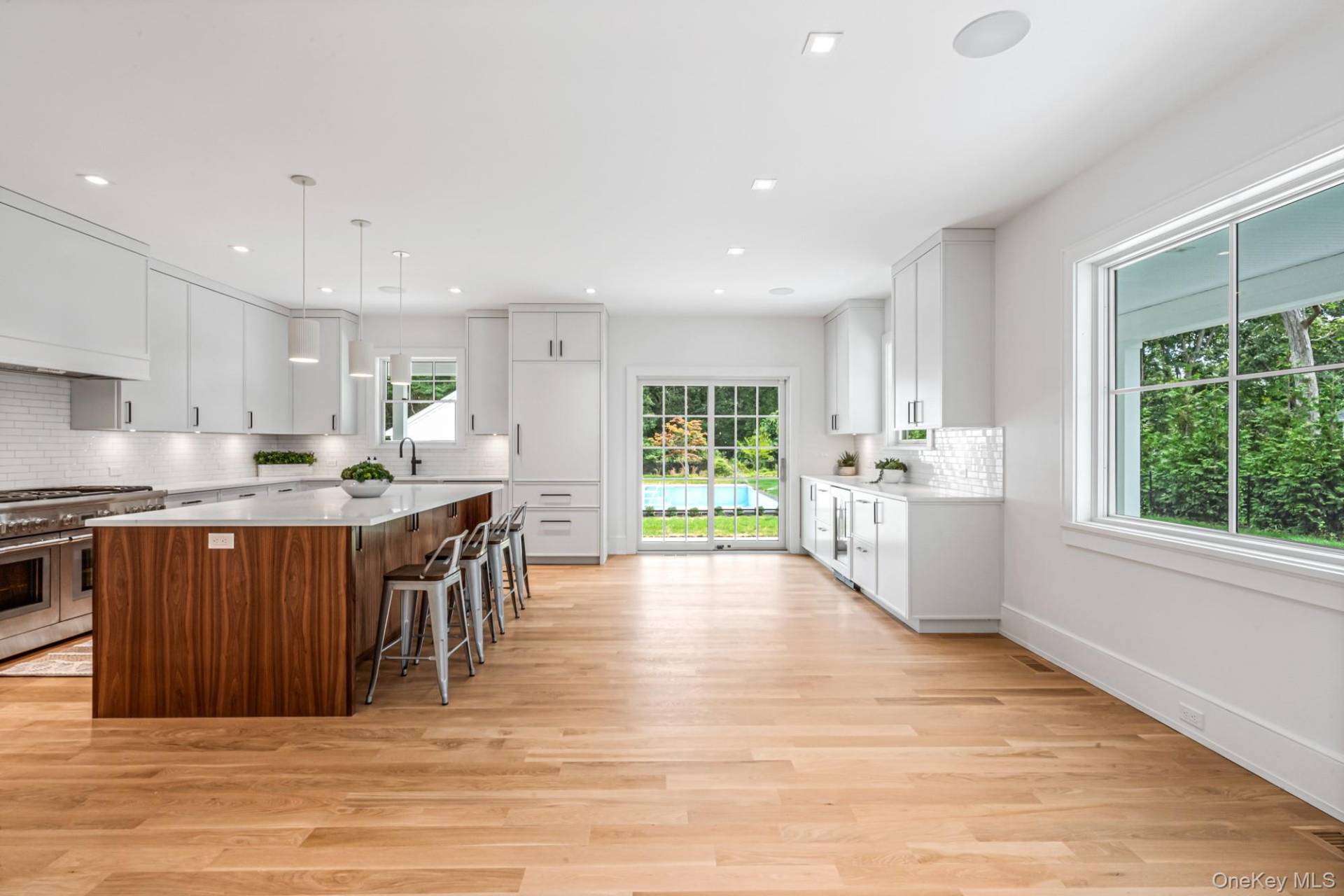 36 Jagger Lane Westhampton, NY 11977 - Photo 12 of 41 a kitchen with stainless steel appliances granite countertop a stove top oven a sink dishwasher a dining table and chairs with wooden floor