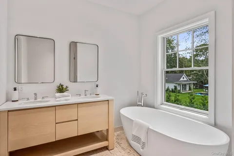 a bathroom with 2 sink tub and a mirror