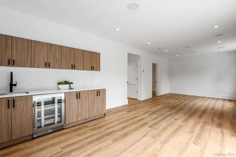 a kitchen with white cabinets a sink and wooden floor