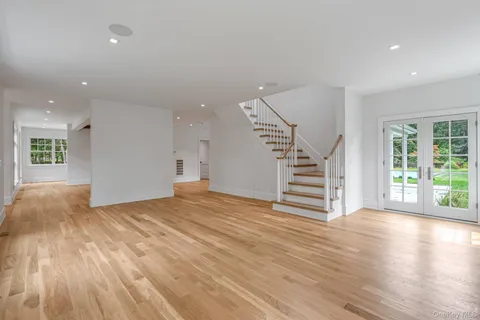a view of a livingroom with wooden floor and stairs