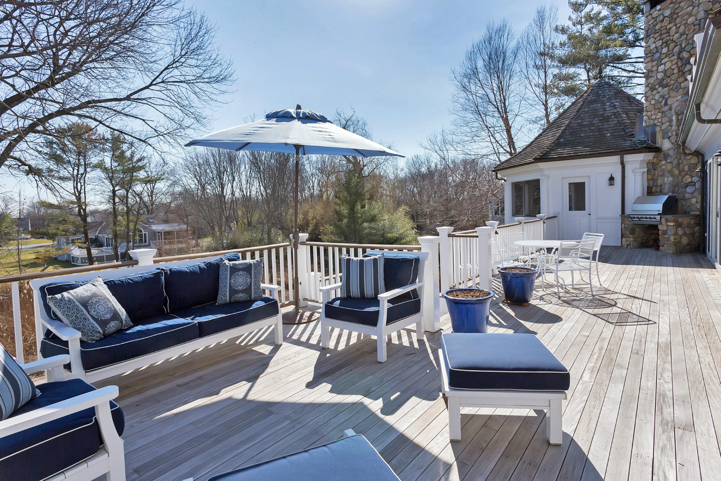 11 Juniper Road Darien, CT 06820 - Photo 25 of 25 a view of a patio with couches table and chairs under an umbrella with wooden floor