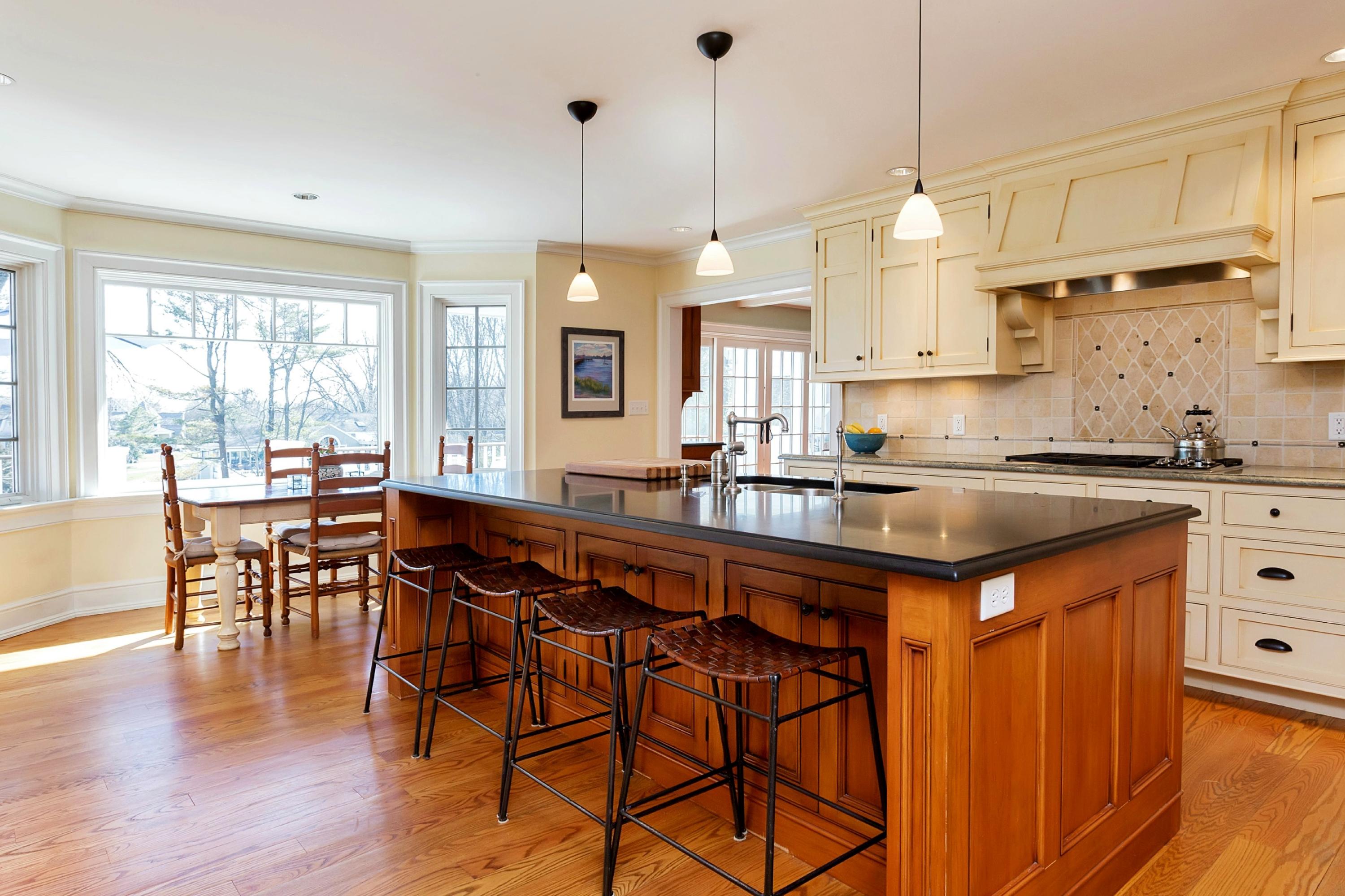 11 Juniper Road Darien, CT 06820 - Photo 9 of 25 a kitchen with stainless steel appliances granite countertop wooden floors stove a sink a dining table and chairs