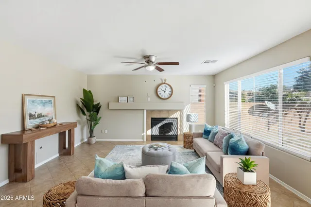 a living room with furniture a fireplace and a large window