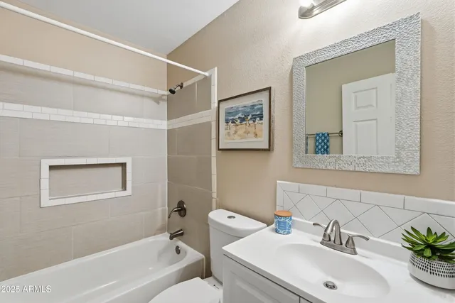 a bathroom with a sink mirror vanity and toilet
