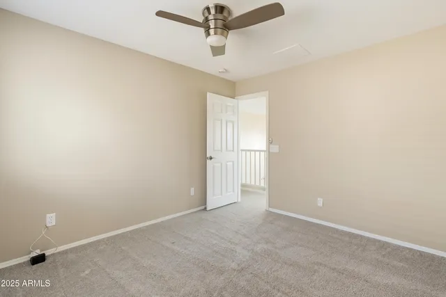 an empty room with a ceiling fan and window