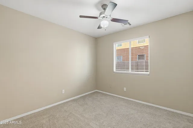 an empty room with a window and a fan