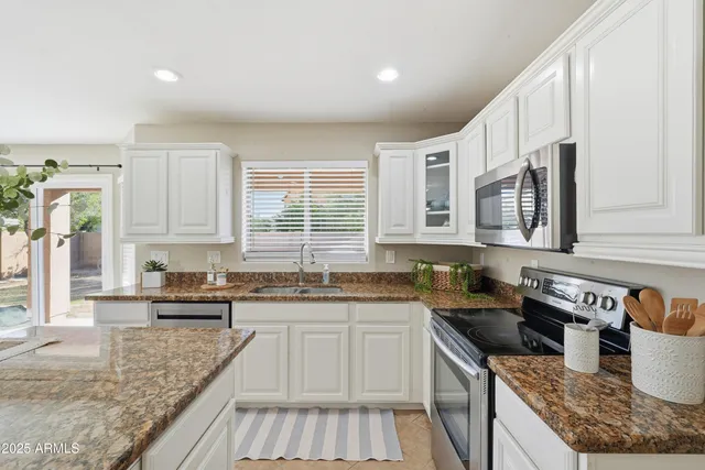 a kitchen with stainless steel appliances granite countertop a sink stove and cabinets