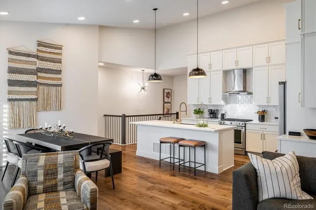 a kitchen with a dining table chairs stove and white cabinets