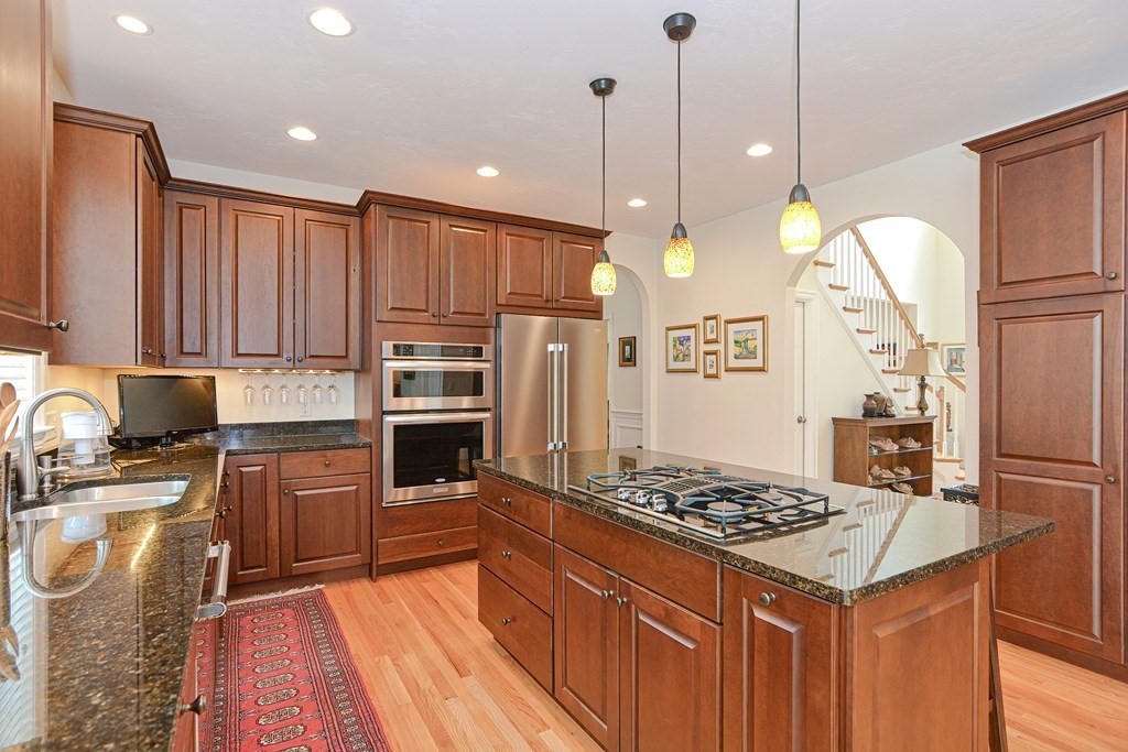 1 Ridgewood Street Ashland, MA 01721 - Photo 6 of 30 a kitchen with kitchen island granite countertop a stove a sink a oven and a refrigerator with wooden floor