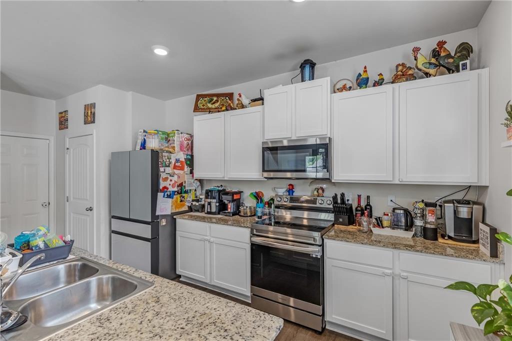 575 Walnut Grv Way Pendergrass, GA 30567 - Photo 14 of 39 a kitchen with stainless steel appliances granite countertop a sink stove and refrigerator