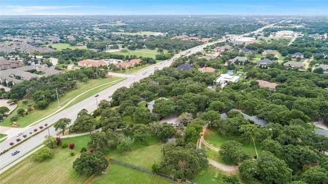 an aerial view of residential houses with outdoor space and trees