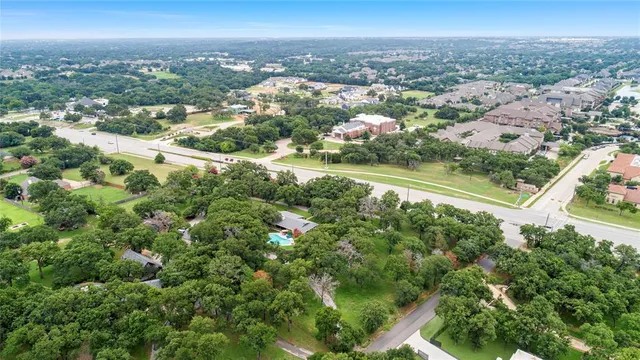an aerial view of residential houses with outdoor space and trees