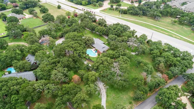 an aerial view of residential house with outdoor space and trees all around